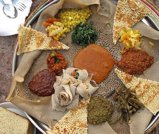 Eritre mutfağı, Doğu Afrika’nın en özgün gastronomi kültürlerinden birini temsil eder. Ülke, tarih boyunca Arap, Osmanlı ve İtalyan etkisi altında kalmıştır. Bu etkileşimler, Eritre sofralarına hem baharatlı hem de Akdeniz esintili tatlar kazandırmıştır. Eritre halkının yemek kültürü, hem yerel tarım ürünlerini hem de dış kültürlerin getirdiği teknikleri bir araya getirerek benzersiz bir mutfak ortaya çıkarmıştır. Konulu bir haber görseli.