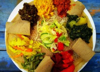 Etiyopya mutfağı, Afrika’nın doğusunda yer alan bu kadim ülkenin kültürel mirasını yansıtan eşsiz bir gastronomi deneyimi sunar. Bu mutfak, yüzyıllar boyunca farklı kültürlerin ve yerel geleneklerin bir araya gelmesiyle şekillenmiştir. Baharatlar, tahıllar ve sebzelerin yoğun kullanımı, Etiyopya yemeklerini hem lezzetli hem de besleyici kılar. Ülkenin farklı bölgelerinde yetişen malzemeler, yemeklerin her birine kendine özgü bir karakter kazandırır. Bu nedenle Etiyopya yemekleri, hem yerel halk hem de turistler tarafından büyük ilgi görmektedir. Konulu bir haber görseli.