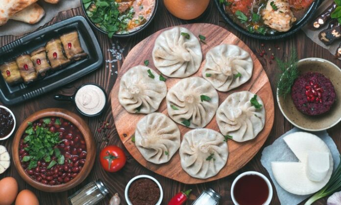 Gürcistan Mutfağı Gürcistan mutfağı, Kafkasya’nın tarihi ve kültürel zenginliğini sofralarına yansıtan köklü bir gastronomi geleneğine sahiptir. Yüzyıllardır farklı medeniyetlerin etkisiyle şekillenen bu mutfak, hem Doğu hem de Batı lezzetlerini bir araya getirir. Ülkenin farklı bölgelerinde yetişen sebze, meyve, tahıl ve et ürünleri, mutfak kültürünün çeşitlenmesini sağlamıştır. Gürcüler için yemek, yalnızca karın doyurmak değil, aynı zamanda kültürel bir paylaşım ve misafirperverlik göstergesidir. Konulu bir haber görseli.