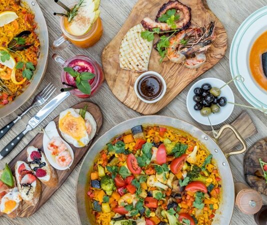 İspanyol Mutfağı İspanyol mutfağı, Akdeniz ikliminin sunduğu bereketli tarım ürünleri ve tarih boyunca süregelen kültürel etkileşimlerle şekillenmiştir. Fenikelilerden Romalılara, Araplardan Yeni Dünya keşiflerine kadar uzanan süreç, mutfağın bugünkü zenginliğinin temelini oluşturur. Arap etkisi, özellikle baharatların, pirincin ve zeytinyağının mutfakta önemli bir yer edinmesini sağlamıştır. Konulu bir haber görseli.