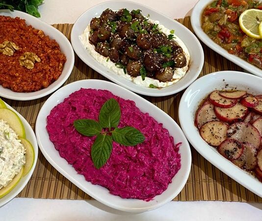 Mezeler, Türk ve Akdeniz mutfaklarının en özel ve zengin yanlarından biridir. Hem ana yemeklerin yanında sunulan hem de tek başına sofraları zenginleştiren bu küçük lezzetler, misafir ağırlamanın da baş tacıdır. Mezeler, farklı malzemelerden oluşan çeşitleriyle her damak tadına hitap ederken, aynı zamanda sofraların renkli ve şık görünmesini sağlar. Pratik hazırlanabilir olmaları ve geniş yelpazede sunulmaları sebebiyle hem evde hem de restoranlarda sıkça tercih edilir. Konulu bir haber görseli.