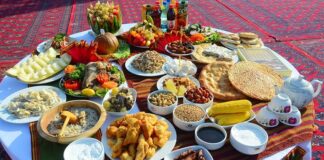 Türkmenistan mutfağı, Orta Asya’nın kurak ve çöl bölgelerinde göçebe yaşam tarzının etkisiyle şekillenmiş, hem pratik hem de besleyici yemeklerle öne çıkan bir mutfaktır. Tarih boyunca hayvancılık, tarım ve baharat kullanımı mutfağın temelini oluşturmuştur. Et ve tahıllar günlük beslenmenin başlıca öğeleri iken, sebzeler ve baharatlar yemeklere zengin bir tat ve aroma kazandırır. Konulu bir haber görseli.