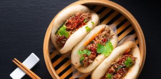 Bao Bun Lezzetinin Dünya Mutfağındaki Yükselişi Bao Bun, Çin mutfağının en sevilen hamur işleri arasında yer alır. Yumuşacık dokusu ve farklı iç malzemeleriyle dikkat çeken bu lezzet, özellikle Uzak Doğu mutfağına meraklı olanların ilgisini çeker. Geleneksel olarak buharda pişirilen hamurdan yapılan Bao Bun, iç harcına göre etli, sebzeli veya tatlı alternatiflerle hazırlanabilir. Kökeni Çin’in kuzey bölgelerine dayanan bu yiyecek, yüzyıllar boyunca hem halk sofralarında hem de özel günlerde kendine yer bulmuştur. Konulu bir haber görseli.