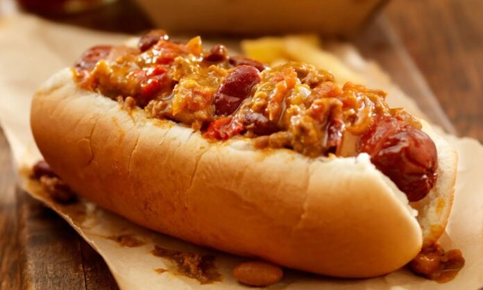Amerika mutfağının en sevilen sokak lezzetlerinden biri olan chili dog, klasik hot dog’un baharatlı bir versiyonudur. Kökeni 20. yüzyılın başlarına uzanan bu yiyecek, özellikle Teksas ve Kaliforniya sokaklarında popüler hale gelmiştir. Klasik sosis ve ekmek kombinasyonunun üzerine eklenen acılı chili sos, chili dog’un karakteristik özelliğini oluşturur. Konulu bir haber görseli.