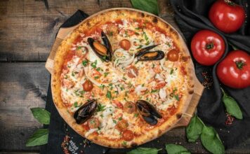 Deniz Mahsullü Pizza: Denizden Gelen Lezzetin Hamurla Buluşması Deniz mahsullü pizza, klasik İtalyan pizzalarının deniz ürünleriyle zenginleştirilmiş modern bir yorumudur. Akdeniz ve İtalyan mutfağından ilham alan bu pizza, dünya genelinde kısa sürede popülerlik kazanmıştır. Özellikle taze deniz ürünleri ve kaliteli malzemelerin birleşimi, pizzayı hem lezzet hem de görsellik açısından özel kılar. Konulu bir haber görseli.