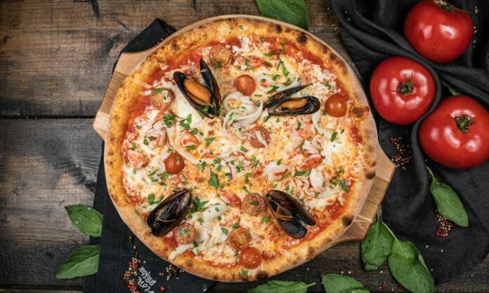 Deniz Mahsullü Pizza Denizden Gelen Lezzetin Hamurla Buluşması Deniz mahsullü pizza, klasik İtalyan pizzalarının deniz ürünleriyle zenginleştirilmiş modern bir yorumudur. Akdeniz ve İtalyan mutfağından ilham alan bu pizza, dünya genelinde kısa sürede popülerlik kazanmıştır. Özellikle taze deniz ürünleri ve kaliteli malzemelerin birleşimi, pizzayı hem lezzet hem de görsellik açısından özel kılar. Konulu bir haber görseli.