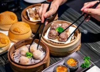 Dim Sum Lezzetinin Küresel Yolculuğu ve Popülerliği Dim Sum, Çin mutfağının en köklü ve sevilen geleneklerinden biridir. Çay kültürüyle özdeşleşen bu yemek türü, küçük porsiyonlar halinde servis edilen çeşitli yiyeceklerden oluşur. Tarihi, yüzyıllar öncesine dayanan bu lezzet, özellikle Guangdong bölgesinde ortaya çıkmış ve zamanla Çin’in farklı bölgelerine yayılmıştır. Yolculara hızlı ve doyurucu yiyecek sunma amacıyla başlayan bu gelenek, bugün hem Çin mutfağının hem de dünya gastronomisinin vazgeçilmez bir parçası haline gelmiştir. Konulu bir haber görseli.
