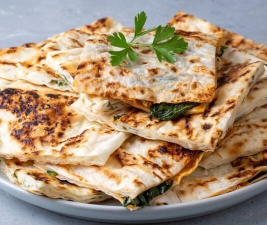 Türk mutfağının en sevilen hamur işi lezzetlerinden biri olan gözleme, geçmişten günümüze gelen bir miras olarak sofralarda yerini koruyor. Yüzyıllardır Anadolu’da farklı bölgelerde yapılan gözleme, her yörenin kendine özgü tarifleriyle çeşitlilik kazanıyor. İnce açılmış hamurun arasına konulan farklı iç harçlarıyla hazırlanan bu lezzet, sadece Türkiye’de değil, dünyada da giderek daha çok tanınmaya başlıyor. Özellikle turistlerin ilgisini çeken gözleme, geleneksel Türk kahvaltılarının ve sokak lezzetlerinin ayrılmaz bir parçası haline geldi. Konulu bir haber görseli.