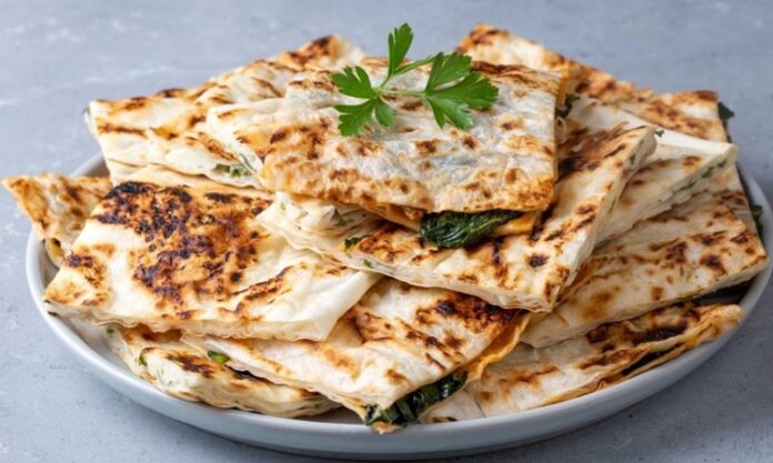Gözleme Türk Mutfağının Vazgeçilmez Lezzeti Türk mutfağının en sevilen hamur işi lezzetlerinden biri olan gözleme, geçmişten günümüze gelen bir miras olarak sofralarda yerini koruyor. Yüzyıllardır Anadolu’da farklı bölgelerde yapılan gözleme, her yörenin kendine özgü tarifleriyle çeşitlilik kazanıyor. İnce açılmış hamurun arasına konulan farklı iç harçlarıyla hazırlanan bu lezzet, sadece Türkiye’de değil, dünyada da giderek daha çok tanınmaya başlıyor. Özellikle turistlerin ilgisini çeken gözleme, geleneksel Türk kahvaltılarının ve sokak lezzetlerinin ayrılmaz bir parçası haline geldi. Konulu bir haber görseli.