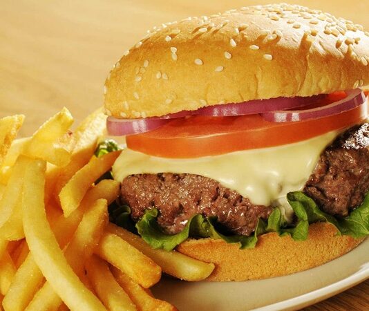 Hamburger, günümüzde hızlı yemek kültürünün en bilinen simgelerinden biridir. Ancak bu lezzetin kökenleri çok daha eskilere dayanır. Almanya’nın Hamburg şehrinden adını alan hamburger, Amerika’da popülerleşmiş ve kısa sürede küresel bir fenomen haline gelmiştir. Bugün dünyanın neredeyse her köşesinde farklı çeşitleriyle tüketilen hamburger, yalnızca bir yiyecek değil aynı zamanda modern yaşamın simgelerinden biri olmuştur. Konulu bir haber görseli.