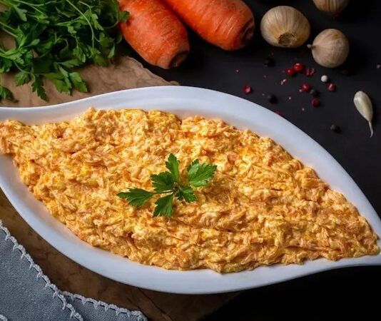 Havuç Tarator, Türk mutfağının en sevilen mezelerinden biri olarak öne çıkar. Özellikle akşam yemeklerinde veya davet sofralarında hafif ve lezzetli bir başlangıç olarak servis edilir. Havuç taratorun kökeni Anadolu mutfağına dayanmakla birlikte, zamanla farklı yöresel tariflerle çeşitlenmiştir. Konulu bir haber görseli.