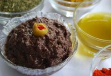 Zeytin ezmesi, yüzyıllardır özellikle Akdeniz mutfak kültüründe kendine özel bir yer edinmiş sağlıklı bir lezzettir. Anadolu’da kahvaltı sofralarının vazgeçilmezi olarak bilinen bu eşsiz tat, sadece kahvaltılarda değil farklı yemeklerin yanında da tüketilmektedir. Zeytin ağacının binlerce yıllık geçmişi, bu ürünü adeta bir kültürel miras haline getirmiştir. Bu nedenle, özellikle köylerde yapılan doğal yöntemlerle hazırlanmış zeytin ezmesi, sofralarda hem lezzeti hem de sağlık açısından sunduğu faydalar ile tercih edilmektedir. Konulu bir haber görseli.