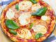 Margarita Pizza: Klasik İtalyan Lezzetinin Sofralardaki Yükselişi Margarita pizza, İtalyan mutfağının en ikonik lezzetlerinden biri olarak bilinir. Napoli kökenli bu pizza türü, basit ama dengeli malzemeleriyle ün kazanmıştır. Domates, mozzarella peyniri ve taze fesleğen kullanımı, pizzanın üç temel rengi olan kırmızı, beyaz ve yeşili simgeler. Konulu bir haber görseli.