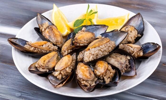 Türk mutfağının en bilinen sokak lezzetlerinden biri olan midye dolma, kökeni Osmanlı dönemine kadar uzanan köklü bir geçmişe sahiptir. Saray mutfağında farklı baharatlarla hazırlanan pirinçli yemeklerin deniz ürünleriyle birleşmesi sonucu ortaya çıktığı düşünülmektedir. Zamanla bu lezzet, sokaklara taşınarak herkesin ulaşabileceği bir hale gelmiştir. Konulu bir haber görseli.