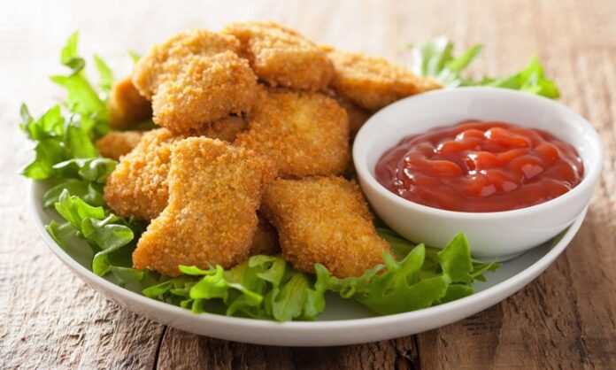 Nugget Pratik Atıştırmalıkların Lezzetli Tercihi Nugget, özellikle hızlı ve pratik öğün arayanların favori seçeneklerinden biri haline gelmiş bir yiyecektir. Kökeni Amerika’ya dayanan bu atıştırmalık, 1950’li yıllarda geliştirilmiş ve kısa sürede dünya çapında popüler olmuştur. Tavuk eti, kaplamalı ve kızartılmış olarak hazırlanarak altın sarısı bir dış yüzeye kavuşur. Konulu bir haber görseli.