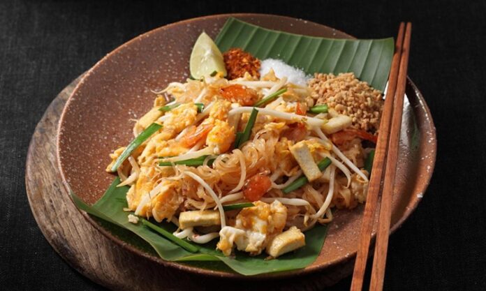 Pad Thai Dünyanın En Sevilen Uzak Doğu Lezzetlerinden Biri Pad Thai, Tayland mutfağının en bilinen yemeklerinden biridir ve dünya genelinde milyonlarca insan tarafından sevilerek tüketilmektedir. Bu yemek, özellikle Tayland’ın kimliğini yansıtan bir lezzet olarak öne çıkar. 1930’lu yıllarda ülkenin milli kimliğini güçlendirmek amacıyla öne çıkarılan bu yemek, kısa sürede Tayland’ın ulusal yemeklerinden biri haline gelmiştir. Pirinç eriştesiyle yapılan bu özel yemek, Tayland’ın zengin mutfak kültürünü uluslararası alanda temsil etmektedir. Konulu bir haber görseli.