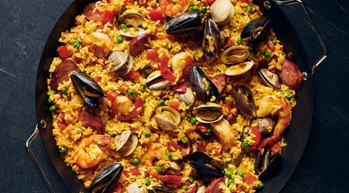 Paella İspanya Mutfağının Renkli Lezzeti Paella, İspanya’nın en bilinen yemeklerinden biri olarak dünya mutfağında önemli bir yere sahiptir. Özellikle Valencia bölgesinde ortaya çıkan bu yemek, zamanla tüm ülkeye ve oradan da dünyaya yayılmıştır. Tarihi 15. yüzyıla kadar uzanan paella, köylülerin tarlalarda buldukları malzemeleri bir araya getirerek pişirdikleri pratik bir yemek olarak doğmuştur. Konulu bir haber görseli.