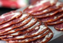 Pastırma dilimi, Türk mutfağının köklü geleneklerinden günümüze taşınmış, eşsiz aroması ve yoğun lezzetiyle sofralarda özel bir yere sahip olan bir üründür. Kayseri başta olmak üzere Anadolu’nun farklı bölgelerinde üretilen pastırma, ince dilimlenerek tüketildiğinde hem kahvaltılarda hem de yemeklerde ayrı bir tat sunar. Yüzyıllardır varlığını koruyan bu özel lezzet, günümüzde de sofraların en çok aranan ürünleri arasında yer almaktadır. Konulu bir haber görseli.