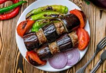 Türk mutfağının vazgeçilmez lezzetlerinden biri olan patlıcan kebabı, özellikle Gaziantep, Şanlıurfa ve Adana gibi şehirlerde sıkça hazırlanır. Patlıcanın közlenip etle buluşmasıyla ortaya çıkan bu yemek, hem hafif hem de doyurucu bir öğün sunar. Osmanlı mutfağından günümüze uzanan tarif, yöresel farklılıklarla her sofrada kendine özgü bir tat bırakır. Konulu bir haber görseli.