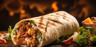 Shawarma: Sokak Lezzetinin Zirvesi Orta Doğu mutfağının en bilinen sokak lezzetlerinden biri olan Shawarma, ince dilimlenmiş etin özel baharatlarla marine edilip dikey döner üzerinde pişirilmesiyle hazırlanır. Genellikle tavuk, dana veya kuzu eti kullanılır ve lavaş veya pita ekmeğiyle servis edilir. Bu lezzet, hem hızlı hem de doyurucu bir öğün alternatifi sunar. Konulu bir haber görseli.