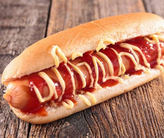 Sokak yemekleri denildiğinde akla gelen ilk lezzetlerden biri olan sosisli sandviç, hızlı ve pratik bir öğün olarak dünya genelinde yaygın olarak tüketilmektedir. Kökeni 19. yüzyılın sonlarına kadar uzanan bu lezzet, özellikle Amerika ve Avrupa sokaklarında popüler hale gelmiştir. Yumuşak sandviç ekmeği arasına yerleştirilen sosis, üzerine ketçap, hardal veya mayonez gibi soslarla tamamlanarak klasik bir tat oluşturur. Konulu bir haber görseli.