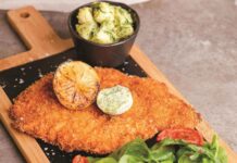 Dünya mutfaklarının en çok tercih edilen lezzetlerinden biri olan tavuk şinitzel, hem pratik hazırlanışı hem de eşsiz tadıyla öne çıkıyor. Avrupa kökenli bu yemek, aslında klasik bir et yemeğinin tavukla uyarlanmış halidir. Alman ve Avusturya mutfağında önemli bir yere sahip olan şinitzel, zamanla farklı kültürlerin mutfağına da girmiştir. Türkiye’de ise tavuk versiyonu daha çok tercih edilmekte, özellikle ev sofralarında ve restoran menülerinde sıkça karşımıza çıkmaktadır. Konulu bir haber görseli.