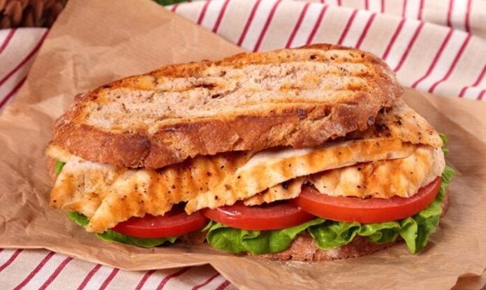 Tavuklu sandviç, günümüzde en çok tercih edilen pratik öğünlerden biri olarak öne çıkar. Kökeni, 20. yüzyılın başlarına kadar uzanan bu sandviç, hızlı hazırlanan ve doyurucu bir yemek alternatifi olarak popülerlik kazanmıştır. İlk olarak Amerika ve Avrupa’da yaygınlaşan tavuklu sandviç, kısa sürede dünya mutfaklarında standart bir seçenek haline gelmiştir. Konulu bir haber görseli.