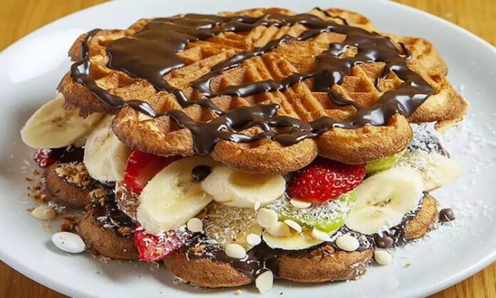 Waffle Tatlı Severlerin Vazgeçilmez Lezzeti Waffle, Belçika kökenli, çıtır dışı ve yumuşak içi ile bilinen tatlı hamur ürünüdür. Orta Çağ’dan bu yana Avrupa’da tüketilen bu lezzet, zamanla Amerika ve diğer kıtalara yayılmıştır. Geleneksel olarak kahvaltıda veya tatlı saatlerinde tercih edilen waffle, taze meyve, çikolata veya karamel sosla servis edilir. Konulu bir haber görseli.