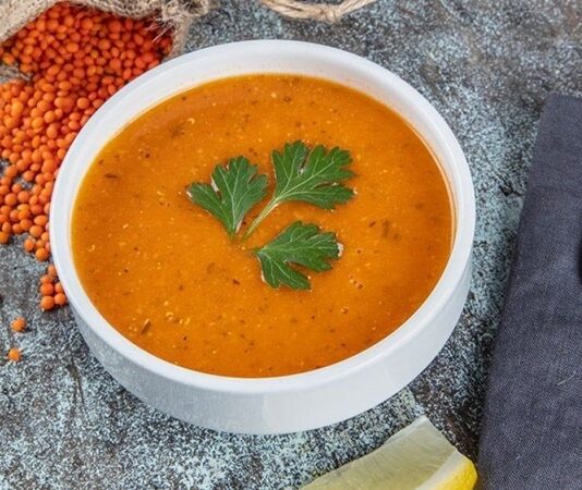 Türkiye’nin en köklü çorba geleneklerinden biri olan Ezogelin çorbası, hem hikâyesi hem de besleyici yapısıyla son yıllarda yeniden yükselişe geçti. Gaziantep’in Oğuzeli ilçesinden tüm ülkeye yayılan bu özel çorba, yalnızca damak tadıyla değil, arkasındaki duygusal anlatıyla da halk arasında ayrı bir değer görüyor. Çevrim içi tarif platformlarında ve sosyal medya içeriklerinde popülerleşen Ezogelin çorbası, bugün özellikle gençlerin de ilgi duyduğu klasiklerden biri haline geldi. Restoranlardan ev mutfaklarına kadar uzanan bu geniş ilgi, çorbanın geleneksel kimliğini koruyarak modern mutfaklarda da güçlü bir yer edindiğini gösteriyor. Konulu bir haber görseli.