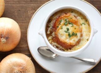 Dünya mutfağının en etkileyici ve simgesel lezzetlerinden biri olan Fransız soğan çorbası, hem Fransa’nın hem de küresel gastronomi dünyasının vazgeçilmezlerinden biri hâline gelmiştir. Orta Çağ’dan bu yana Fransız halk mutfağında kendine yer bulan bu çorba, zamanla uluslararası arenada da tanınmış ve birçok ülkenin restoran menülerinde yer almaya başlamıştır. Sade bir malzeme listesine sahip gibi görünen Fransız soğan çorbası, karamelize soğan, et suyu ve üzerine eklenen peynirli ekmek ile zenginleşerek hem doyurucu hem de aromatik bir deneyim sunar. Konulu bir haber görseli.