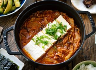 Güney Kore mutfağının en ikonik çorbalarından biri olan Kimchi Jjigae, son yıllarda dünya genelinde hem restoran menülerinde hem de ev yapımı tariflerde popülerliğini artırıyor. Özellikle fermente lahana, baharatlı biber ve dengeli et suyu ile hazırlanan bu çorba, hem doyurucu hem de sağlık açısından zengin bir yemek olarak öne çıkıyor. Türkiye’de de gastronomi meraklılarının ilgisini çeken Kimchi Jjigae, Kore mutfağının globalleşmesinde önemli bir rol oynuyor. Lezzeti ve besleyici özellikleri sayesinde çorba severler için hem geleneksel hem de modern alternatifler sunuyor. Konulu bir haber görseli.