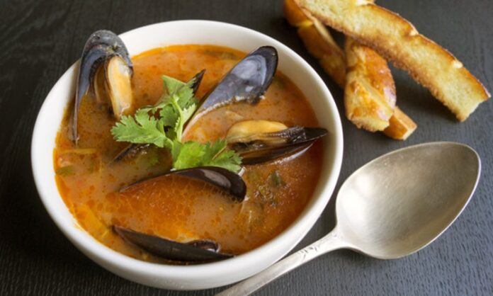 Tomato soup with mussels. With fried croutons on a black backgro Deniz ürünleri severler için özel bir seçenek olan midye çorbası, hem hafif hem de besleyici yapısıyla sofralarda öne çıkıyor. Taze midye, aromatik baharatlar ve çeşitli sebzelerle birleştiğinde hem lezzet hem de sağlık açısından zengin bir öğün sunuyor. Özellikle akşam yemeklerinde veya özel davetlerde başlangıç olarak tercih edilen bu çorba, denizden gelen doğal tatları sofralara taşıyor. Konulu bir haber görseli.