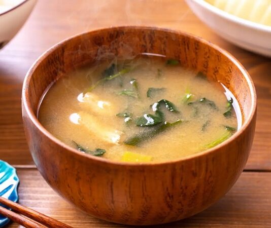 Miso Çorbasının Sırrı Ve Sağlık Üzerindeki Etkileri Miso, Japon mutfağının vazgeçilmez lezzetlerinden biridir ve son yıllarda dünya genelinde sağlıklı beslenme trendleri arasında önemli bir yer kazanmıştır. Miso, fermente edilmiş soya fasulyesi ve tuzdan elde edilen geleneksel bir Japon gıdasıdır. Sade görünmesine rağmen, içerdiği zengin besin değerleri sayesinde hem lezzet hem de sağlık açısından büyük faydalar sunar. Japon kültüründe günlük beslenmenin ayrılmaz bir parçası olan miso, çorba, sos ve hatta bazı tatlı tariflerinde bile kullanılmaktadır. Konulu bir haber görseli.