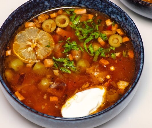 Solyanka, Doğu Avrupa’nın köklü mutfak kültürünü yansıtan, aroması yoğun, baharatı dengeli ve malzemeleri çeşitlilik gösteren özel bir çorbadır. Tarihi Rusya, Ukrayna ve Belarus gibi ülkelerin geleneksel sofralarına kadar uzanan bu yemek, yıllar içinde farklı şekillerde yorumlanmış ve her bölgede kendine özgü bir tat kazanmıştır. Günümüzde dünya gastronomisinde yeniden yükselen ilgi sayesinde solyanka, yalnızca bir çorba olmanın ötesine geçerek kültürel bir temsil niteliği taşımaya başlamıştır. Özellikle güçlü ekşi-aromalı yapısı ve doyurucu özelliği, onu diğer çorbalardan ayıran temel faktörler arasında yer alır. Konulu bir haber görseli.