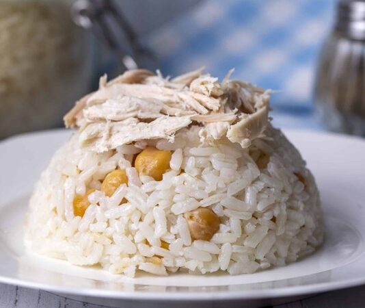 Türk kültüründe yemek, yalnızca beslenme ihtiyacını karşılayan bir unsur değil; aynı zamanda birlik, paylaşma ve bereketin ifadesidir. Bu anlayışın en güçlü örneklerinden biri olan Pilav Günü, Anadolu’nun birçok bölgesinde yüzyıllardır yaşatılan köklü bir gelenek olarak öne çıkar. Büyük kazanlarda pişirilen pilavın topluca dağıtılmasıyla şekillenen bu gün, toplumun farklı kesimlerini aynı sofrada buluşturur. Özellikle köylerde, mahallelerde ve vakıf etkinliklerinde düzenlenen pilav günü, sosyal bağları güçlendiren önemli bir kültürel pratik olarak kabul edilir. Konulu bir haber görseli.