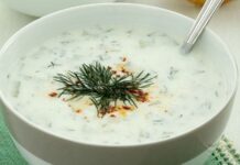 Cacık, Türk mutfağının en sevilen ve ferahlatıcı tariflerinden biri olarak öne çıkıyor. Özellikle yaz aylarında sofraları süsleyen bu yoğurt bazlı karışım, hem hafif hem de besleyici bir seçenek olarak dikkat çekiyor. Cacık hem öğle yemeklerinin yanında hem de akşam yemeklerinde meze olarak sunulabiliyor. Taze nane, salatalık ve sarımsak gibi malzemelerle hazırlanan cacık, sağlıklı ve lezzetli oluşuyla mutfakların vazgeçilmezi haline geliyor. Konulu bir haber görseli.