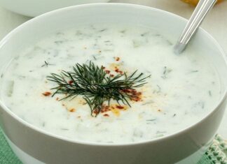 Cacık, Türk mutfağının en sevilen ve ferahlatıcı tariflerinden biri olarak öne çıkıyor. Özellikle yaz aylarında sofraları süsleyen bu yoğurt bazlı karışım, hem hafif hem de besleyici bir seçenek olarak dikkat çekiyor. Cacık hem öğle yemeklerinin yanında hem de akşam yemeklerinde meze olarak sunulabiliyor. Taze nane, salatalık ve sarımsak gibi malzemelerle hazırlanan cacık, sağlıklı ve lezzetli oluşuyla mutfakların vazgeçilmezi haline geliyor. Konulu bir haber görseli.