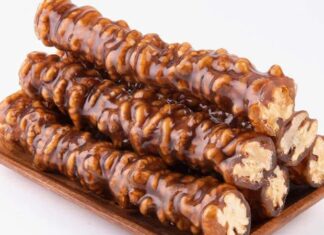 Anadolu mutfağının en sevilen geleneksel tatlarından biri olan cevizli sucuk, özellikle kış aylarının yaklaşmasıyla yeniden gündemde. Doğal içeriği, uzun süre saklanabilmesi ve hem atıştırmalık hem de enerji verici bir yiyecek olarak tüketilmesi, onu her yıl olduğu gibi bu yıl da yoğun ilgi gören bir ürün hâline getiriyor. Üzüm şırasının yoğunlaştırılmasıyla elde edilen karışımın ceviz dizilmiş ipe özenle geçirilip kat kat işlenmesi, bu tatlıyı sadece bir yiyecek olmaktan çıkarıp kültürel bir mirasa dönüştürüyor. Son dönemde yerel üreticilerin doğal yöntemlere dönüş yapmasıyla birlikte cevizli sucuk hem şehir pazarlarında hem de online satışlarda gittikçe daha görünür hâle geliyor. Konulu bir haber görseli.