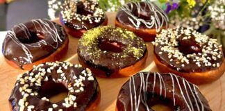 Dünyanın en sevilen tatlılarından biri olan donut, günümüzde yalnızca klasik şekerli halka formundan ibaret değil. Renkli glazeler, çikolata kaplamalar, meyve aromaları ve hatta tuzlu versiyonlarıyla karşımıza çıkan bu tatlı, hem çocukların hem yetişkinlerin ilgisini çekmeye devam ediyor. Özellikle kafe zincirlerinin yaygınlaşmasıyla birlikte donut tercih eden kitlenin her geçen gün arttığı görülüyor. Görsel sunumdaki çeşitlilik, tatlının sosyal medya platformlarında hızla viral olmasına yardımcı oluyor. Konulu bir haber görseli.