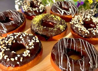 Dünyanın en sevilen tatlılarından biri olan donut, günümüzde yalnızca klasik şekerli halka formundan ibaret değil. Renkli glazeler, çikolata kaplamalar, meyve aromaları ve hatta tuzlu versiyonlarıyla karşımıza çıkan bu tatlı, hem çocukların hem yetişkinlerin ilgisini çekmeye devam ediyor. Özellikle kafe zincirlerinin yaygınlaşmasıyla birlikte donut tercih eden kitlenin her geçen gün arttığı görülüyor. Görsel sunumdaki çeşitlilik, tatlının sosyal medya platformlarında hızla viral olmasına yardımcı oluyor. Konulu bir haber görseli.