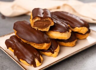 Fransız pastacılığının dünya mutfağına kazandırdığı en özel tatlardan biri olan eclair, yalnızca görünümüyle değil, ince dokusu ve hafif dolgusu ile de tatlı severlerin vazgeçilmezi olarak gösteriliyor. Günümüzde pek çok pastane menüsünde rastladığımız bu tatlı, aslında aristokrat mutfaklarından çıkıp modern mutfaklara taşınan çok katmanlı bir tarihe sahip. Özellikle çikolata kaplaması ve iç dolgusu ile bilinen eclair, Avrupa’da uzun yıllardır tüketilen bir tatlı olmakla birlikte, son yıllarda Türkiye’de de giderek daha fazla tercih edilmeye başladı. Pastacılığın gelişimi ile beraber farklı dolgular, farklı çikolata türleri ve daha çeşitli glazürlerle sunulan bu tatlı, gastronomik açıdan ciddi bir çeşitliliğin de öncüsü haline geldi. Konulu bir haber görseli.