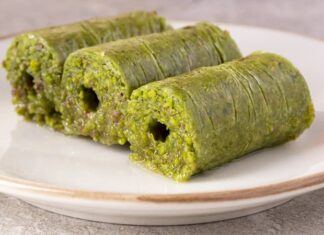 Gaziantep mutfağıyla özdeşleşen fıstık sarma, son yıllarda hem Türkiye’de hem de dünya genelinde gastronomi meraklılarının dikkatini çeken özel tatlılardan biri hâline geldi. İncecik açılan kadayıf hamurunun arasına bolca Antep fıstığı eklenerek hazırlanan bu eşsiz tatlı, hem görünümüyle hem de yoğun aromasıyla öne çıkıyor. Tatlı severlerin ilgisini çeken en önemli özelliklerinden biri ise tamamen doğal malzemelerle hazırlanmasına rağmen oldukça rafine bir lezzet sunması. Üstelik geleneksel tarifin modern dokunuşlarla birleşmesi, fıstık sarmayı son dönemde gurme restoranların da vazgeçilmezi yapıyor. Konulu bir haber görseli.