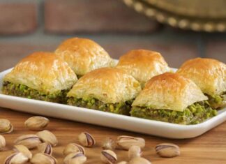 Türkiye’nin en özel tatlılarından biri olan baklava, yüzyıllar boyunca hem coğrafyalara hem de kültürlere yayılan zengin bir mirasa sahip. Orta Asya’dan Anadolu’ya uzanan serüveniyle bugün dünyanın dört bir yanında tanınan bir lezzet hâline gelen baklava, Osmanlı mutfağından itibaren saray sofralarının vazgeçilmez tatlısı olarak kayıt altına alınmıştır. Bu süreçte tatlının yapım teknikleri geliştirilmiş, farklı yörelerde kendine has çeşitleri ortaya çıkmıştır. Gaziantep baklavası, bu tarihsel yolculukta en çok bilinen ve coğrafi işaret tesciline sahip örneklerden biridir. Konulu bir haber görseli.