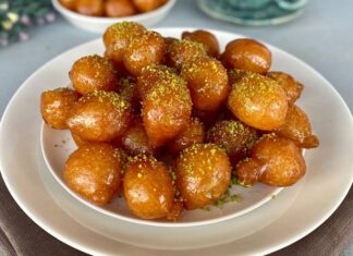 Türkiye’nin en sevilen tatlılarından biri olan lokma tatlısı, geçmişten bugüne gelen bir kültür mirasının lezzete dönüşmüş hâli olarak dikkat çekiyor. Osmanlı mutfağında önemli bir yere sahip olan lokma, günümüzde sokak lezzeti olarak yaygınlaşmış ve neredeyse her şehirde farklı hazırlanış şekilleriyle sunulmaya başlamıştır. Özellikle son yıllarda özel günlerde, hayır etkinliklerinde ve sosyal organizasyonlarda daha sık karşımıza çıkan lokma tatlısı, geleneksel tariften modern tariflere kadar geniş bir çeşitlilik sunmaya devam ediyor. Bu nedenle hem nostalji taşıyan hem de yeniliğe açık bir tatlı olarak gastronomideki yerini pekiştiriyor. Konulu bir haber görseli.