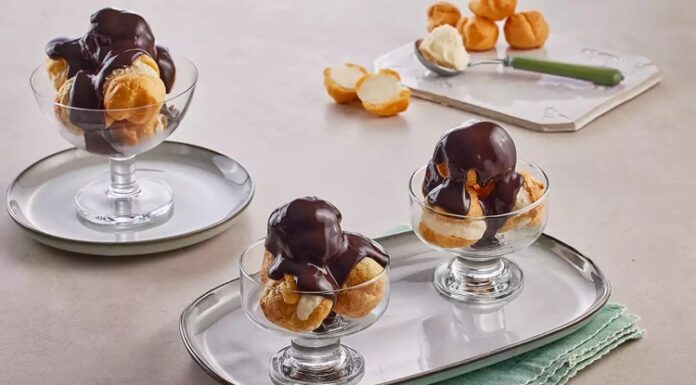 Fransız mutfağının en seçkin tatlılarından biri olan profiterol, uzun yıllardır hem restoranların hem de ev mutfaklarının en sevilen lezzetlerinden biri olarak yerini koruyor. Çıtır hamurun içindeki hafif krema ve üzerine dökülen yoğun çikolata sosuyla oldukça cezbedici bir tat sunan profiterol, özellikle misafir ağırlamalarında şık bir sunum oluşturmasıyla ön plana çıkıyor. Günümüzde pastane vitrinlerinde sıkça görülen bu tatlı, son dönemde ev yapımı tariflerin popülerleşmesiyle birlikte mutfakta daha da yaygın şekilde hazırlanıyor. Konulu bir haber görseli.
