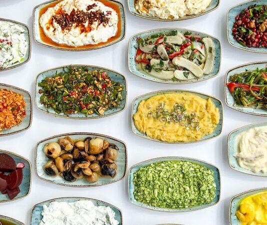 Meze kültürü, yalnızca yemek öncesi iştah açan küçük tabaklardan ibaret olmayan, tarihsel, kültürel ve sosyolojik boyutları olan güçlü bir sofracılık geleneğini temsil eder. Anadolu’dan Akdeniz’e, Balkanlar’dan Orta Doğu’ya uzanan geniş bir coğrafyada meze kültürü, birlikte yeme, paylaşma ve sohbet etme pratiğinin merkezinde yer alır. Bu yönüyle meze, sadece damak tadına değil, toplumsal ilişkilere de hitap eden bir kültür unsurudur. Konulu bir haber görseli.