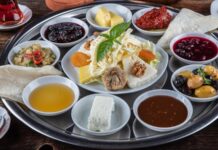 Şehir hayatının yoğun temposundan uzaklaşmak isteyenlerin son yıllarda en çok tercih ettiği gastronomi duraklarından biri köy kahvaltısı mekanları oluyor. Doğal ürünlerle hazırlanan sofralar, sakin ortamlar ve geleneksel tatlar, bu mekanları yalnızca bir kahvaltı noktası değil, aynı zamanda bir deneyim alanı haline getiriyor. Özellikle hafta sonları ailelerin ve arkadaş gruplarının yoğun ilgi gösterdiği köy kahvaltısı mekanları, doğayla iç içe vakit geçirmek isteyenler için güçlü bir alternatif sunuyor. Konulu bir haber görseli.