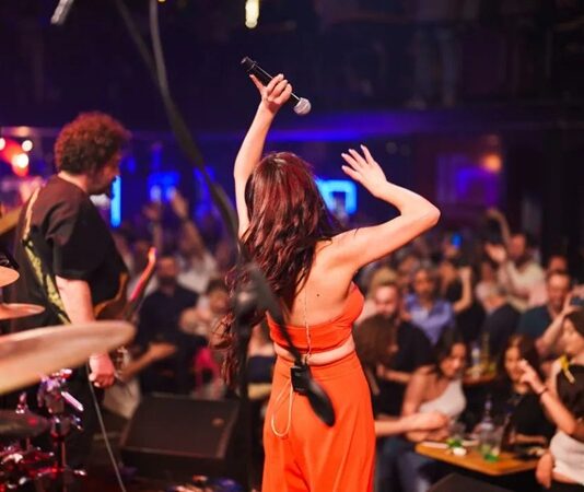 Şehir yaşamının hızına kısa bir mola vermek, müziğin ritmiyle nefes almak isteyenlerin ilk tercihlerinden biri canlı müzik mekanları oluyor. Bu mekânlar, yalnızca müzik dinlenen alanlar değil; aynı zamanda duyguların paylaşıldığı, anıların biriktiği ve sosyal bağların güçlendiği özel buluşma noktaları olarak öne çıkıyor. Farklı müzik türlerini bir araya getiren canlı müzik mekânları, her yaştan ve her zevkten insan için alternatifler sunuyor. Konulu bir haber görseli.