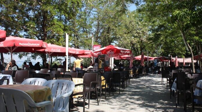 Çay bahçeleri, Türkiye’de gündelik yaşamın en köklü ve en yaygın sosyalleşme alanlarından biri olarak öne çıkıyor. Park kenarlarında, sahil şeritlerinde, mahalle aralarında ya da tarihi meydanlarda karşımıza çıkan çay bahçeleri, her yaştan insanın bir araya geldiği ortak buluşma noktaları olarak dikkat çekiyor. Bu mekânlar, sadece çay içilen yerler değil; sohbetin, dinlenmenin ve gündelik hayatın paylaşıldığı açık hava alanları olarak şehir kültürünün ayrılmaz bir parçası hâline gelmiş durumda. Konulu bir haber görseli.