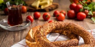 Türkiye’de sokak lezzetleri denildiğinde akla gelen ilk tatlar arasında simit ve açma yer alır. Günün her saatinde ulaşılabilen bu iki hamur işi, yalnızca pratik bir atıştırmalık olmanın ötesinde, şehir yaşamının ritmini belirleyen önemli unsurlardan biri olarak görülür. Sabah işe yetişmeye çalışan bir memurun elinde, okul yolunda koşan bir öğrencinin çantasında ya da sahil kenarında çay eşliğinde tüketilen bu lezzetler, toplumsal hafızanın da güçlü bir parçasıdır. Konulu bir haber görseli.